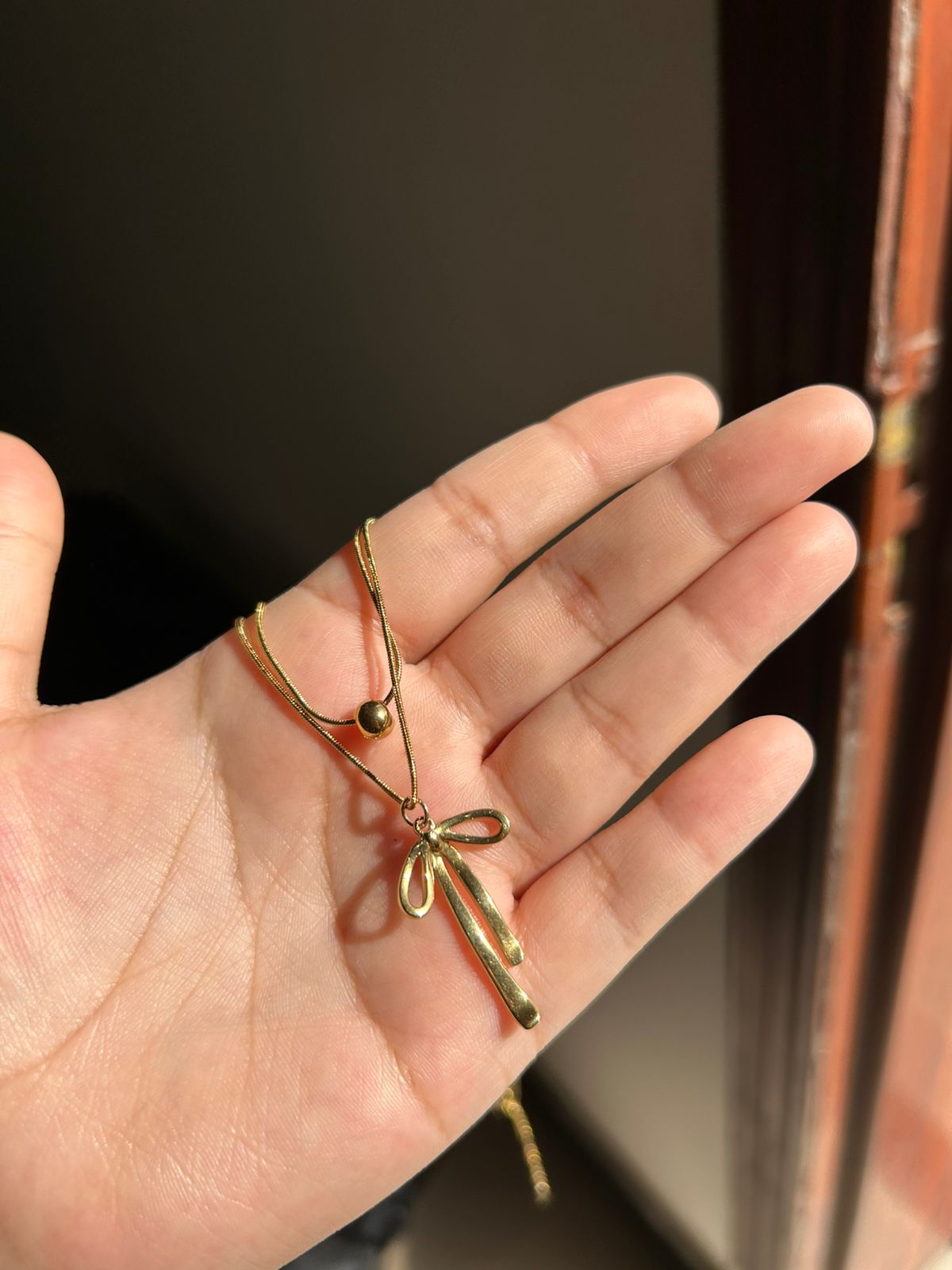 Double chain bow pendant